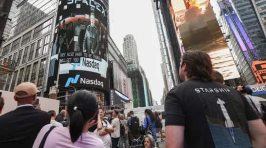 Elon Musk na telebimie wygłasza przemówienie przed debiutem swojej firmy na giełdzie Nasdaq w Nowym Jorku. Fot. PAP/EPA/	PAP/EPA/SARAH YENESEL